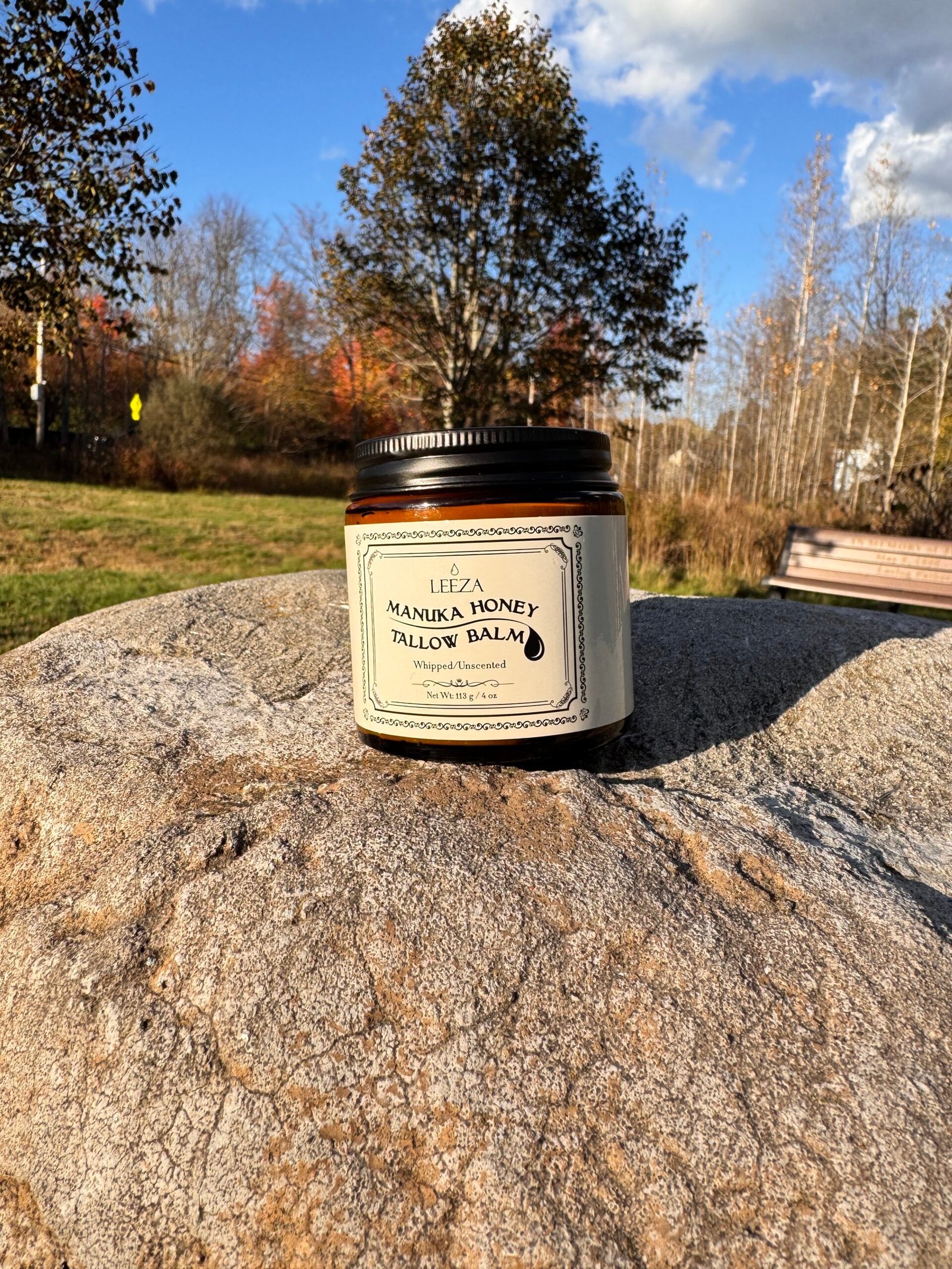 manuka honey tallow balm placed on a stone